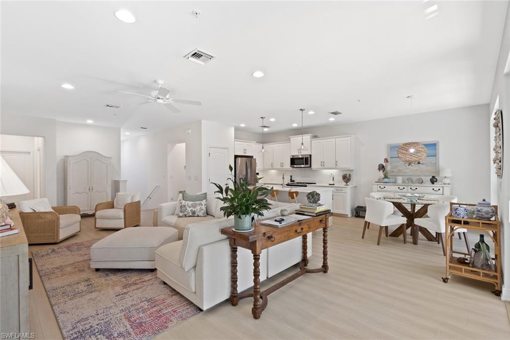 Living area with light wood-type flooring, a ceiling fan, and recessed lighting