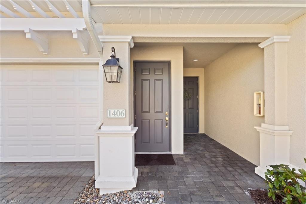 Doorway to property featuring a porch, stucco siding, and driveway