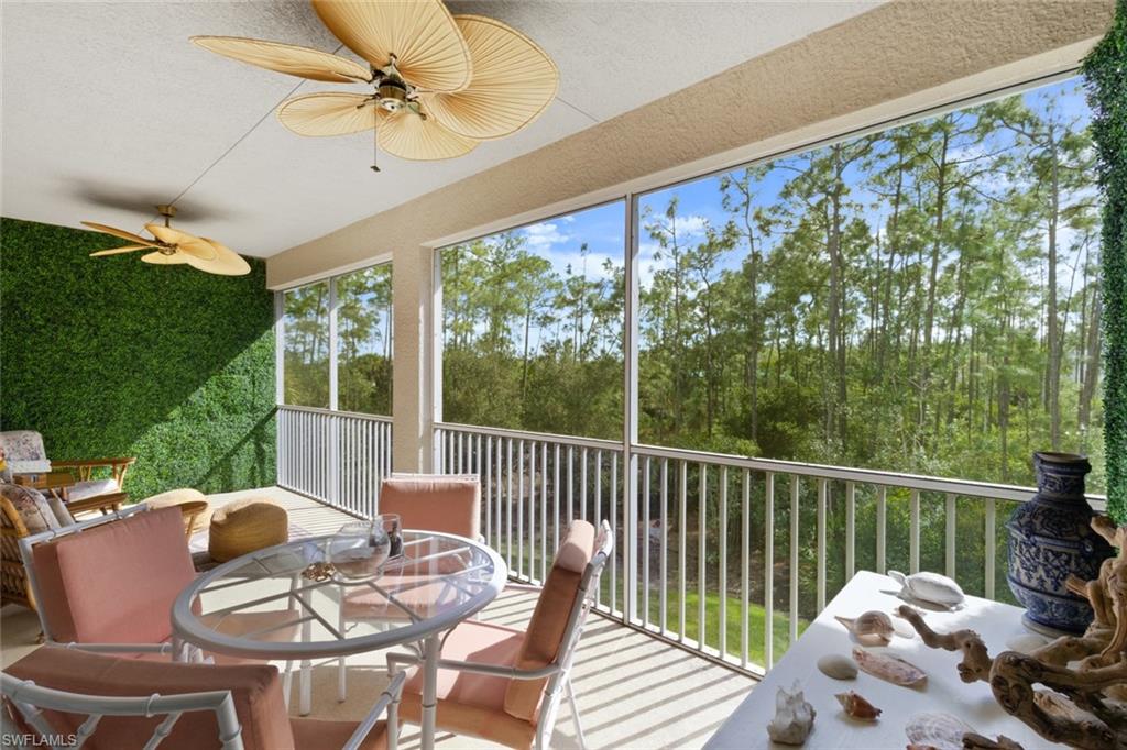 Sunroom / solarium with outdoor dining area, a ceiling fan, and a balcony