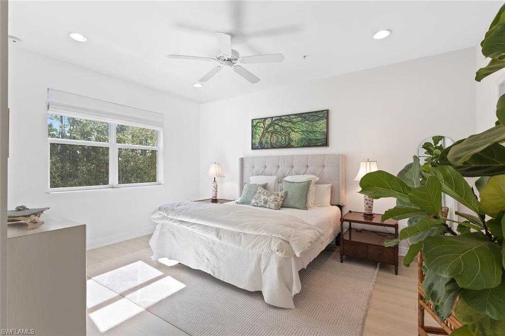 Bedroom with light wood-style floors, ceiling fan, and recessed lighting