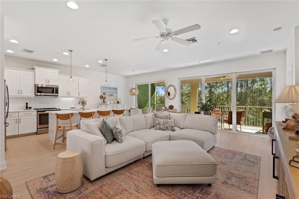 Living area featuring light wood-type flooring, a ceiling fan, and recessed lighting