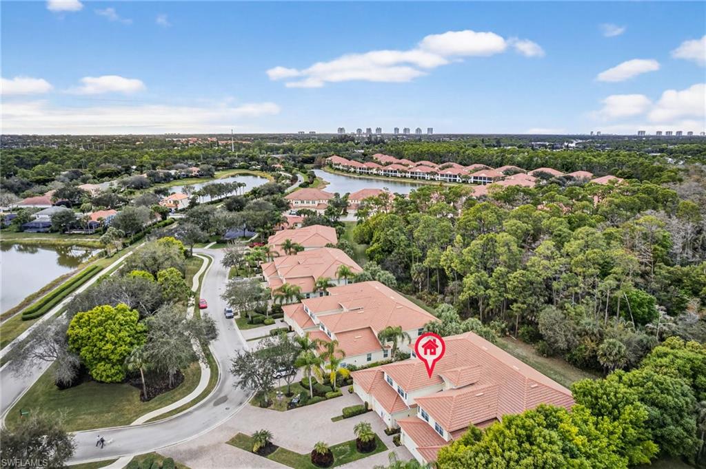 Aerial perspective of suburban area with a large body of water and city skyline