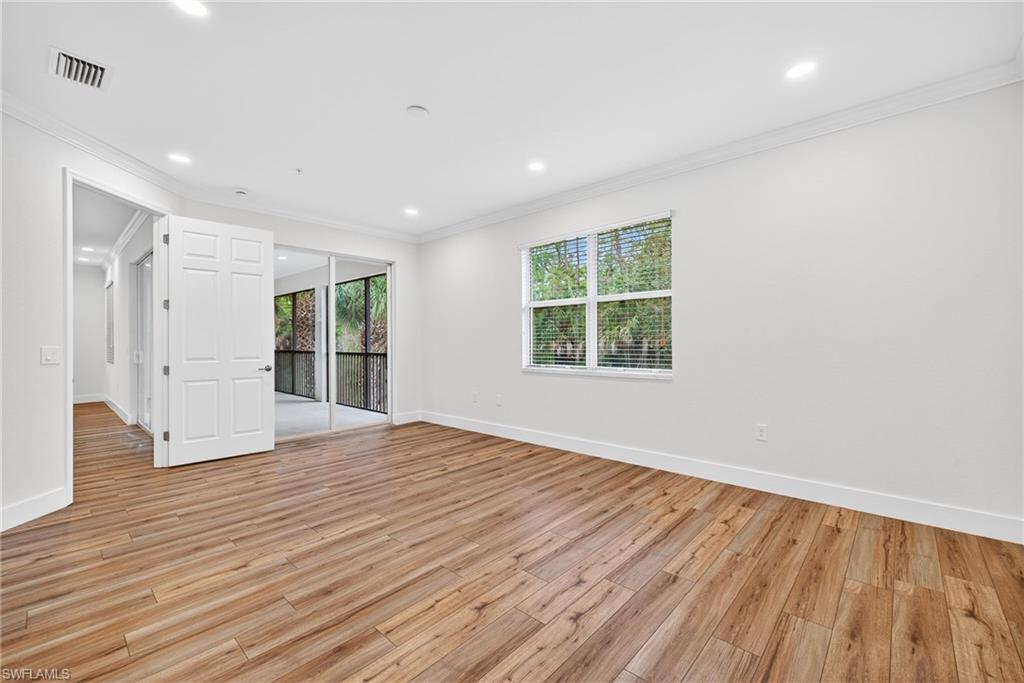 Spare room with ornamental molding, plenty of natural light, light wood-style floors, and recessed lighting