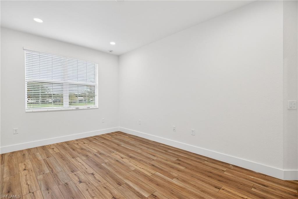 Empty room featuring light wood-type flooring and recessed lighting