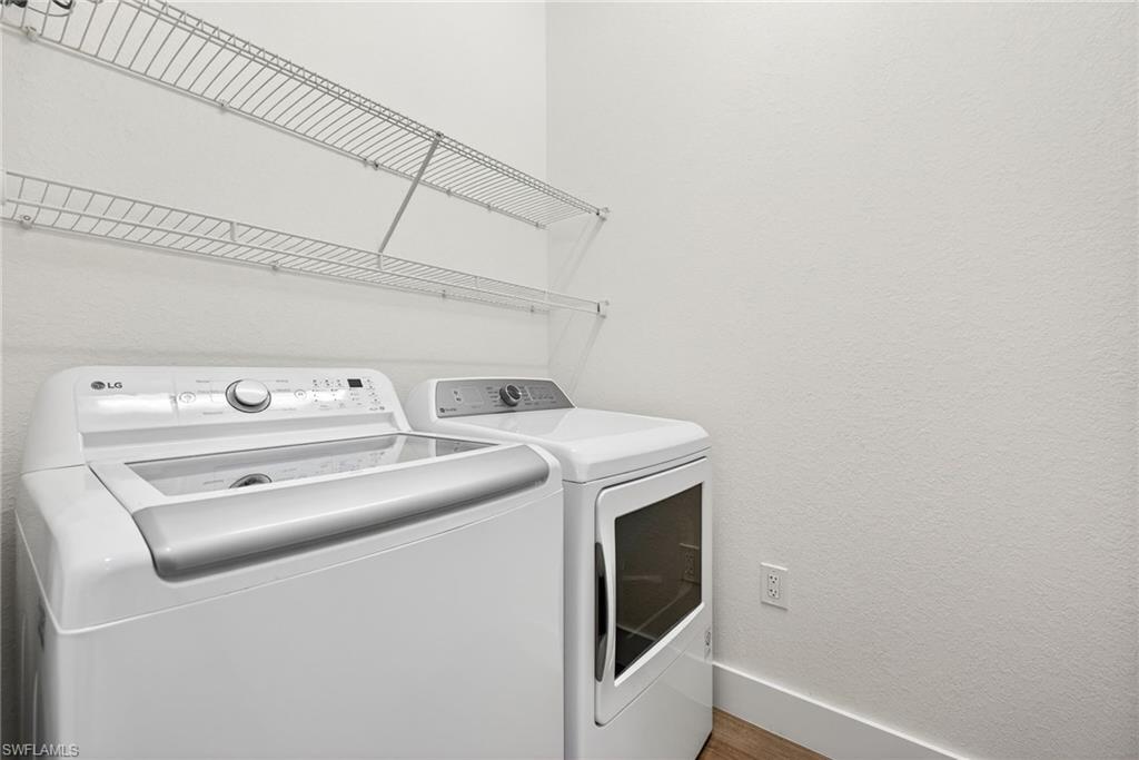 Laundry room with a textured wall and washer and dryer