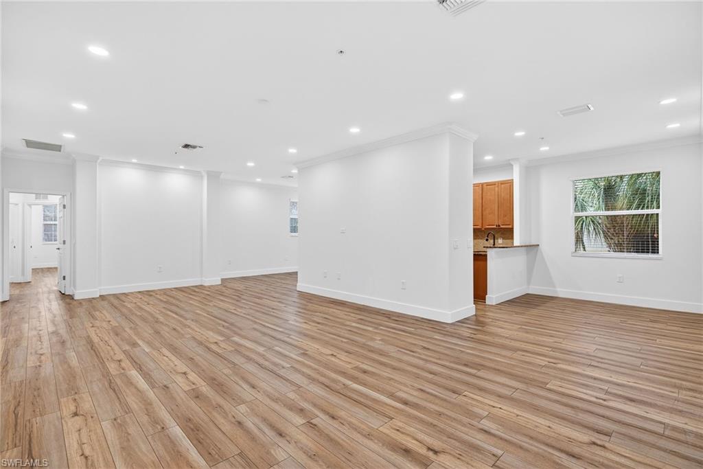 Unfurnished living room featuring crown molding, recessed lighting, and light wood finished floors