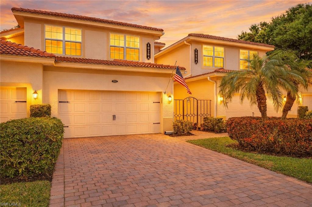 Mediterranean / spanish home featuring a gate, decorative driveway, stucco siding, an attached garage, and a tile roof