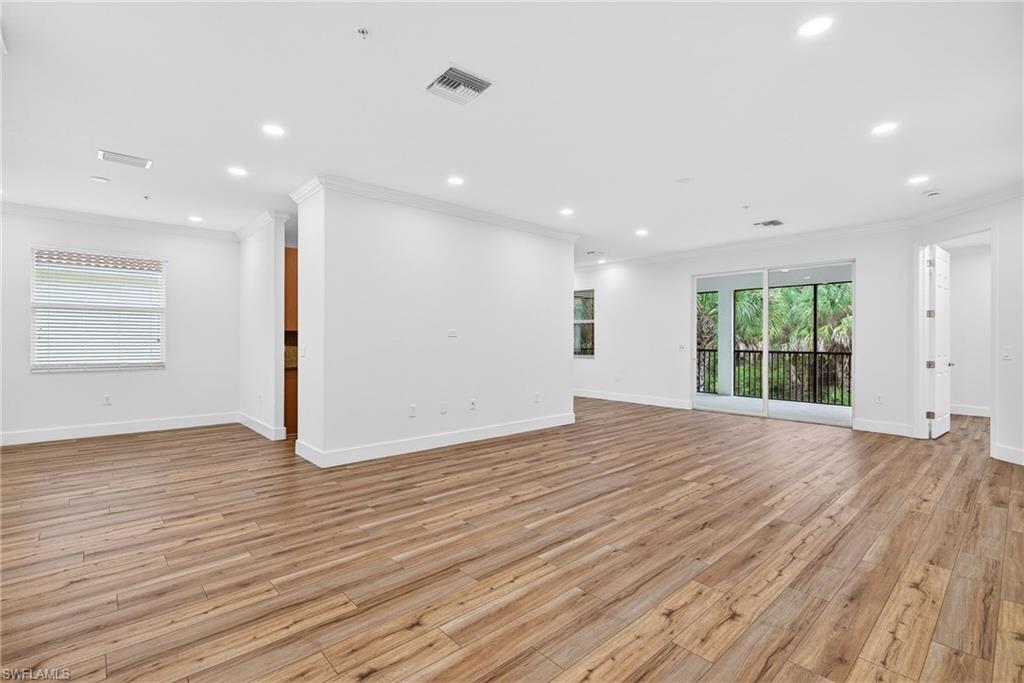Empty room featuring crown molding, light wood-style flooring, and recessed lighting