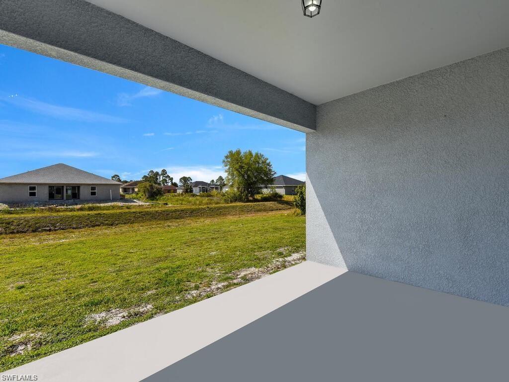 View of grassy yard with a patio and a residential view