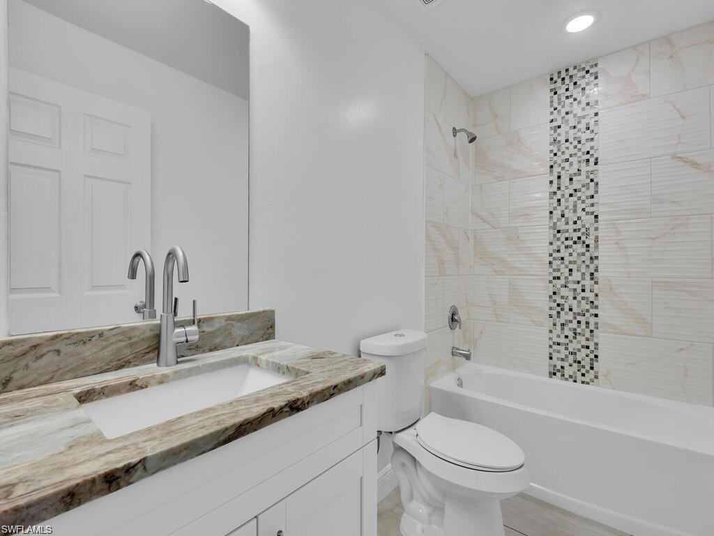 Full bathroom featuring vanity, shower / tub combination, and recessed lighting