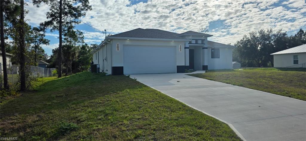 View of front of house with stucco siding, driveway, and an attached garage