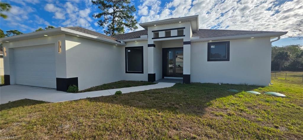 Prairie-style home with an attached garage, stucco siding, roof with shingles, and concrete driveway