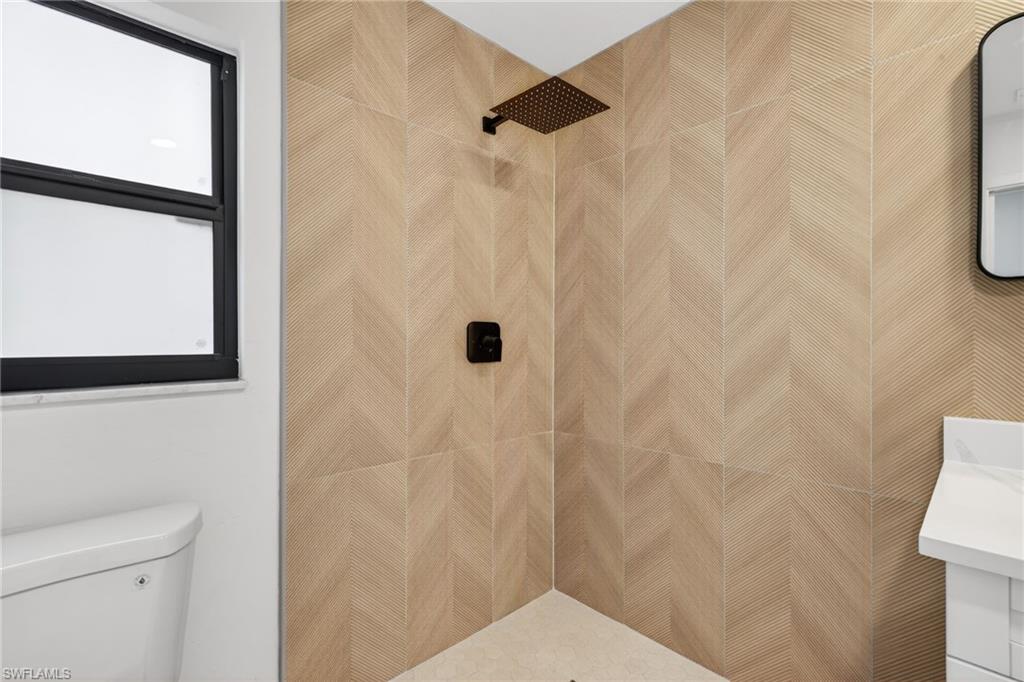 Bathroom with vanity and tiled shower