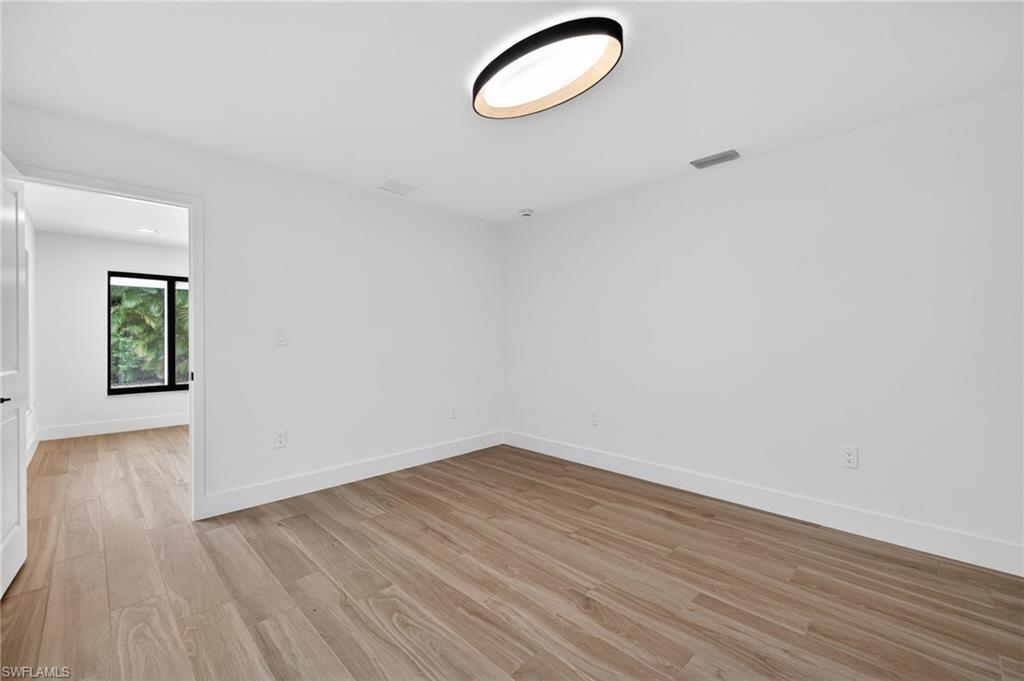 Unfurnished room with light wood-style floors and baseboards