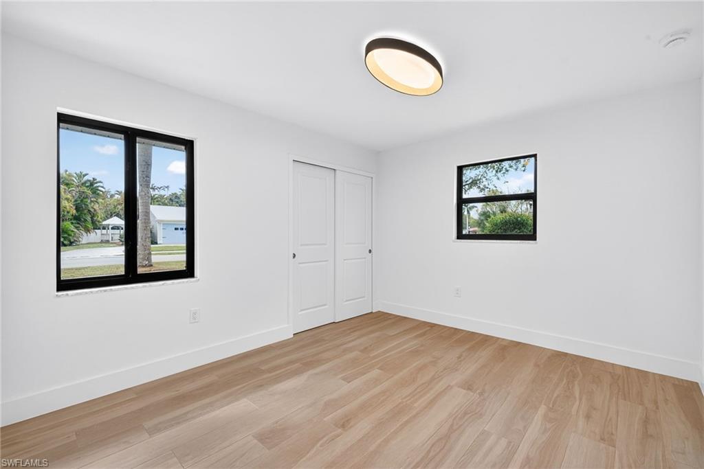 Unfurnished bedroom featuring light wood-style flooring and a closet