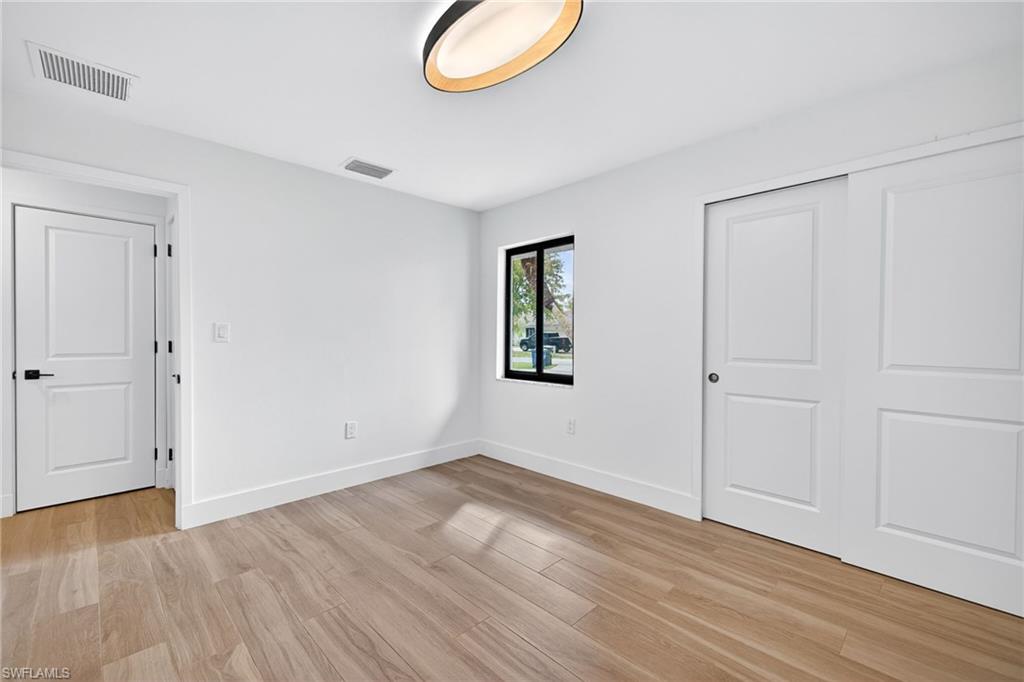 Unfurnished bedroom featuring light wood-style floors and a closet