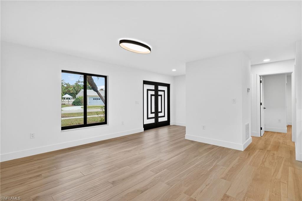 Empty room with light wood finished floors and recessed lighting