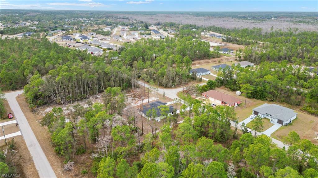Aerial overview of property's location featuring a forest and nearby suburban area