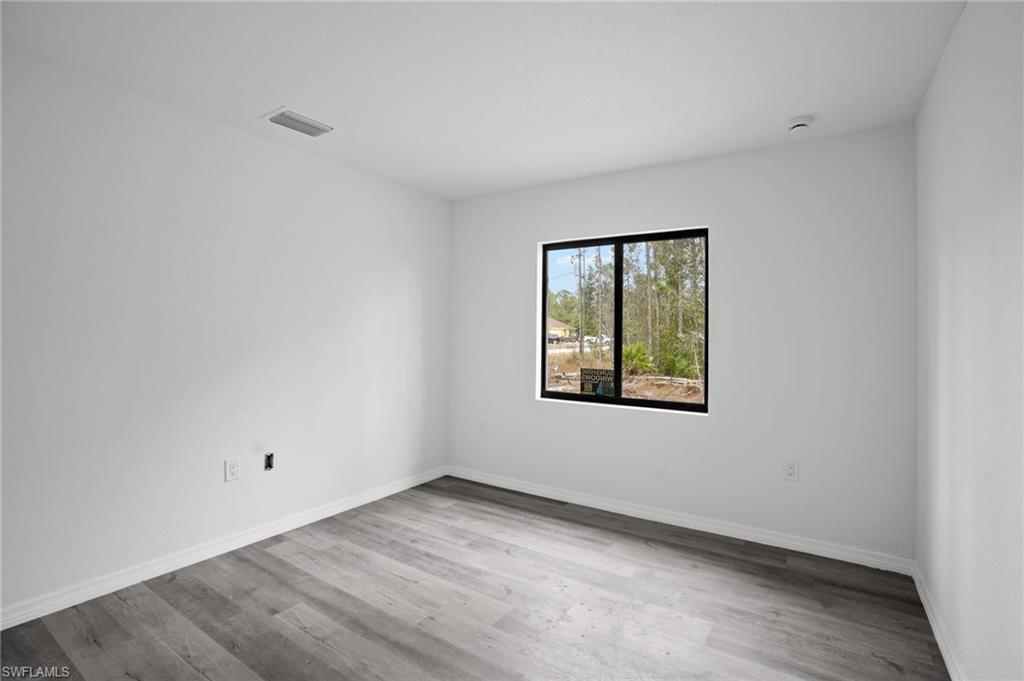 Empty room with light wood-type flooring and baseboards