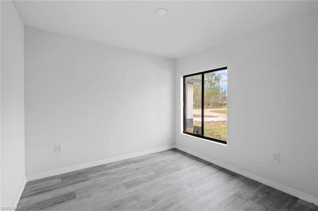 Unfurnished room featuring baseboards and wood finished floors