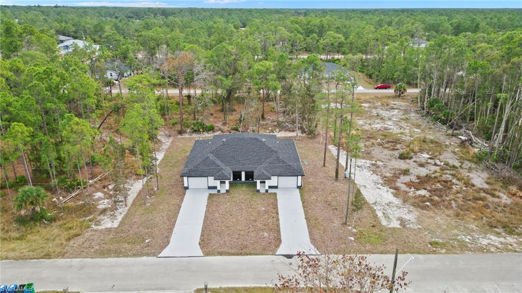 Aerial view of property and surrounding area featuring a heavily wooded area