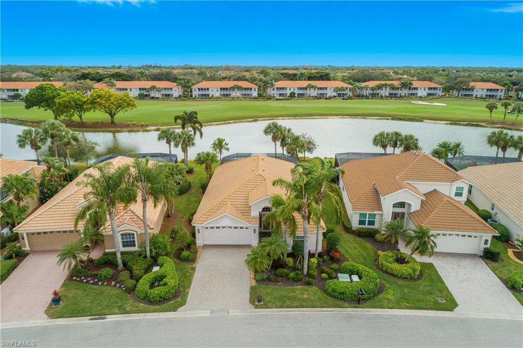 Aerial view of residential area featuring a large body of water and a local golf course