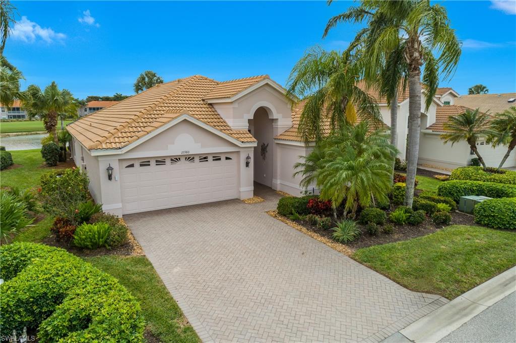 Front of home featuring stucco siding, decorative driveway, an attached garage, and a tiled roof