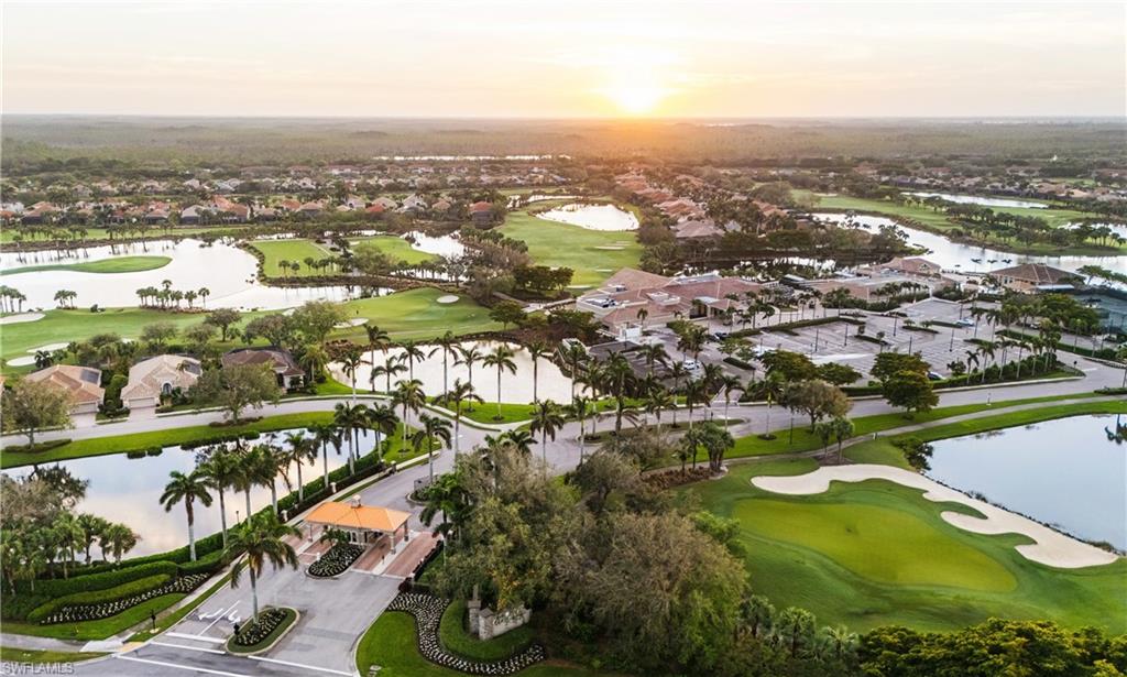 Aerial view at dusk of golf course view, a water view, and a residential view
