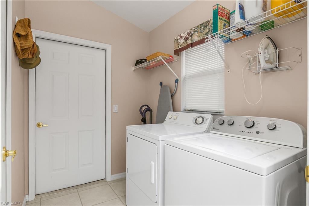 Laundry area featuring washer and dryer and light tile patterned floors