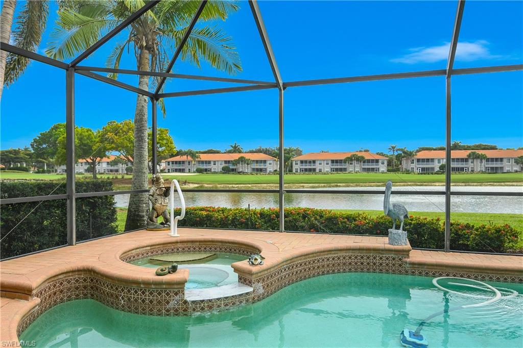 Outdoor pool with glass enclosure, an in-ground hot tub, a sunroom, and a water view