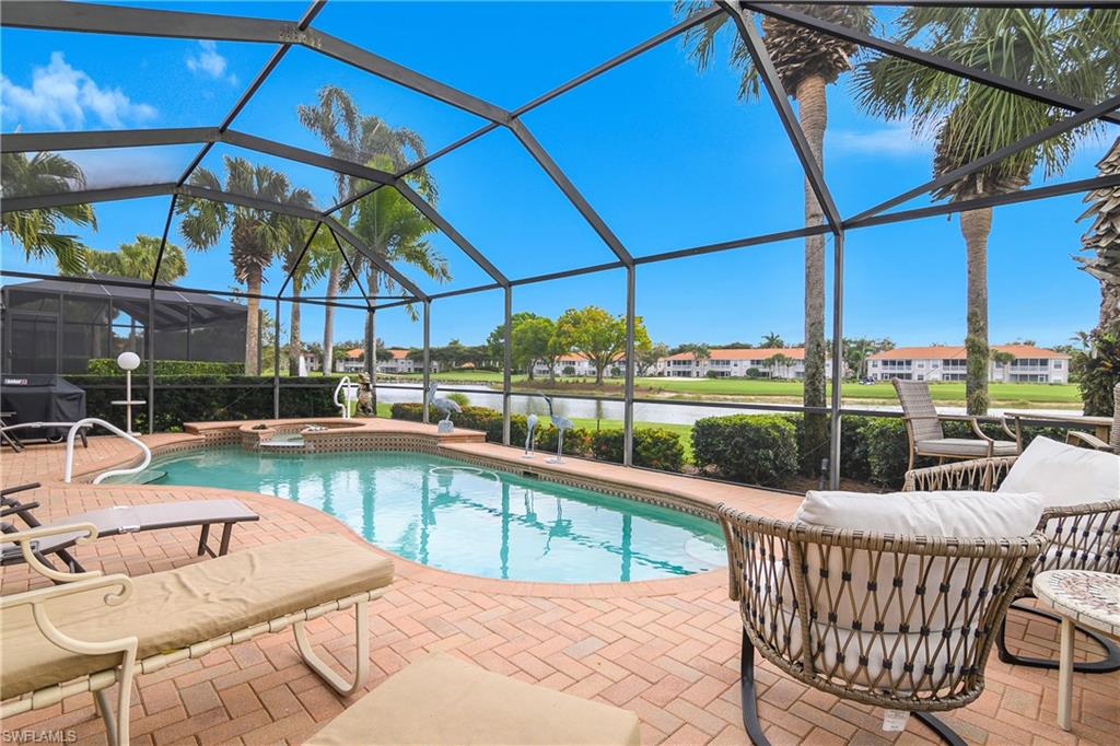 View of pool with a sunroom, glass enclosure, a pool with connected hot tub, a residential view, and a water view
