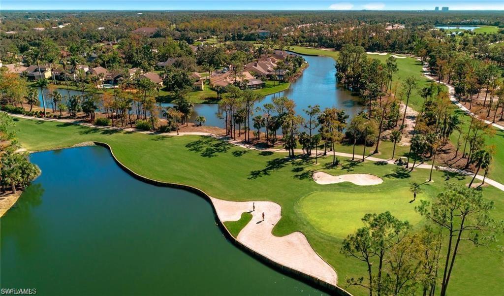 Aerial perspective of suburban area with a large body of water and a golf club