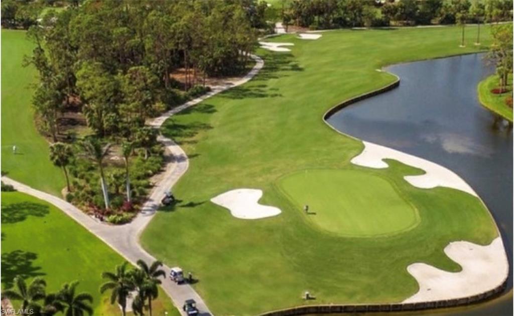 View of home's community with a putting green, a water view, golf course view, and view of wooded area