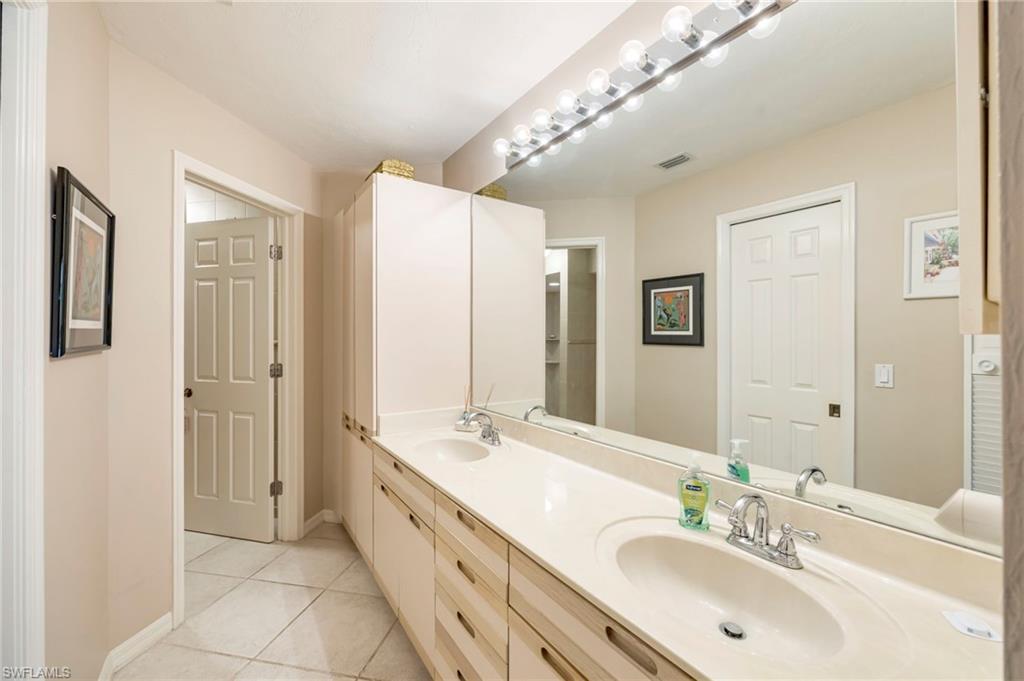 Bathroom featuring double vanity and light tile patterned floors