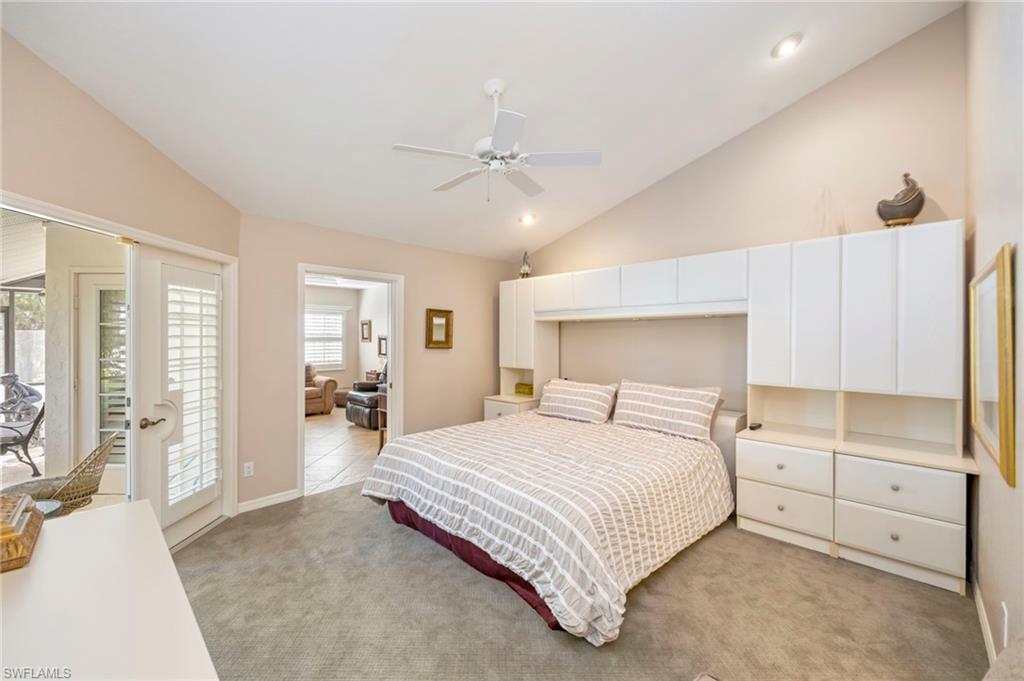 Bedroom with lofted ceiling, light carpet, and ceiling fan