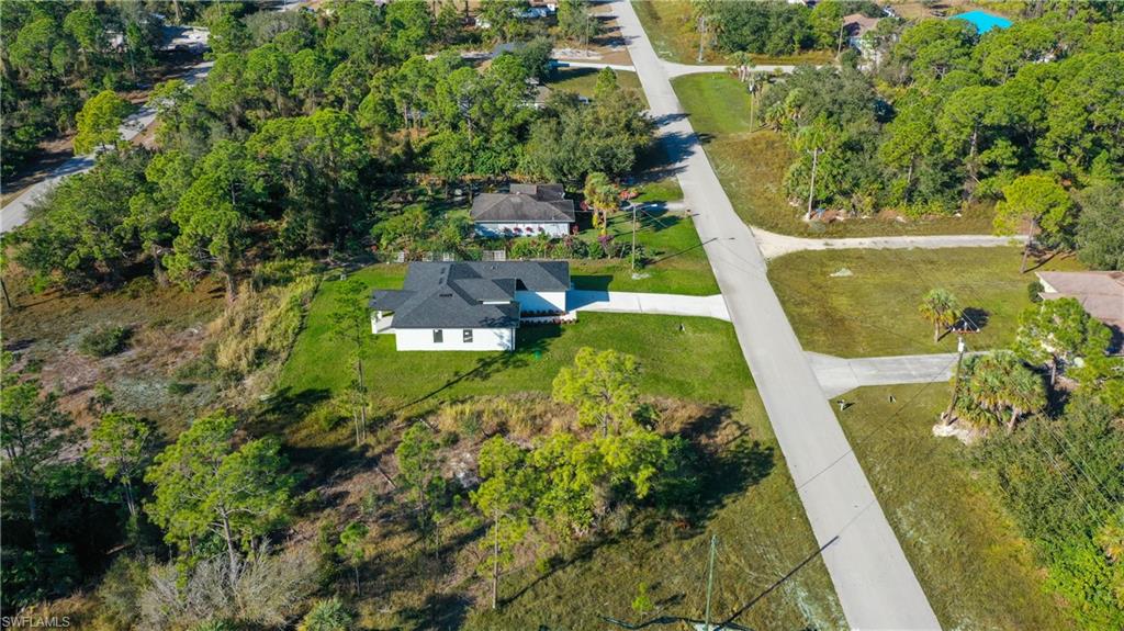 Aerial view of property's location featuring a tree filled landscape