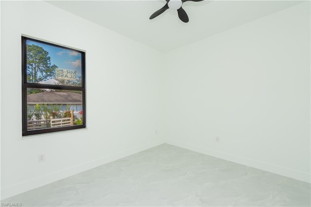 Unfurnished room with baseboards and ceiling fan
