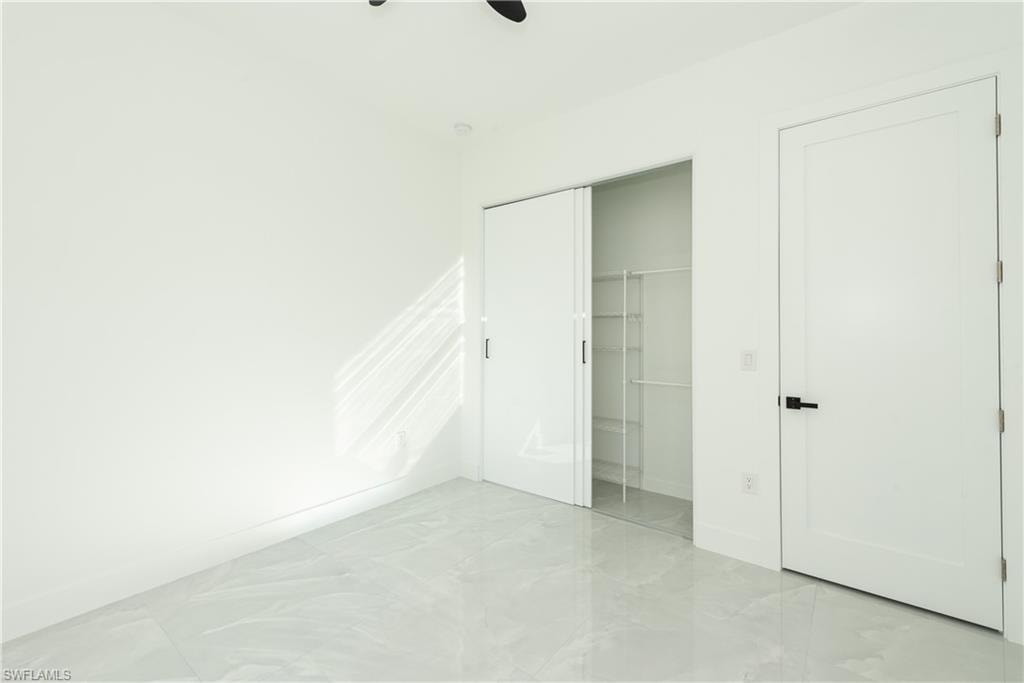 Unfurnished bedroom featuring a closet and a ceiling fan