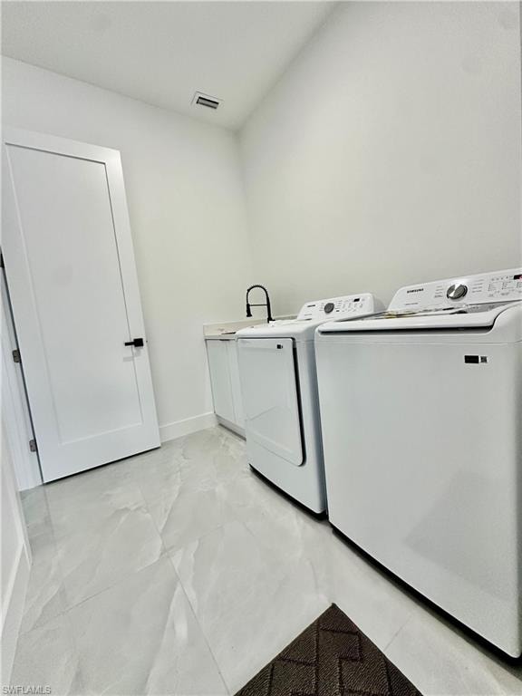 Laundry room featuring separate washer and dryer and cabinet space