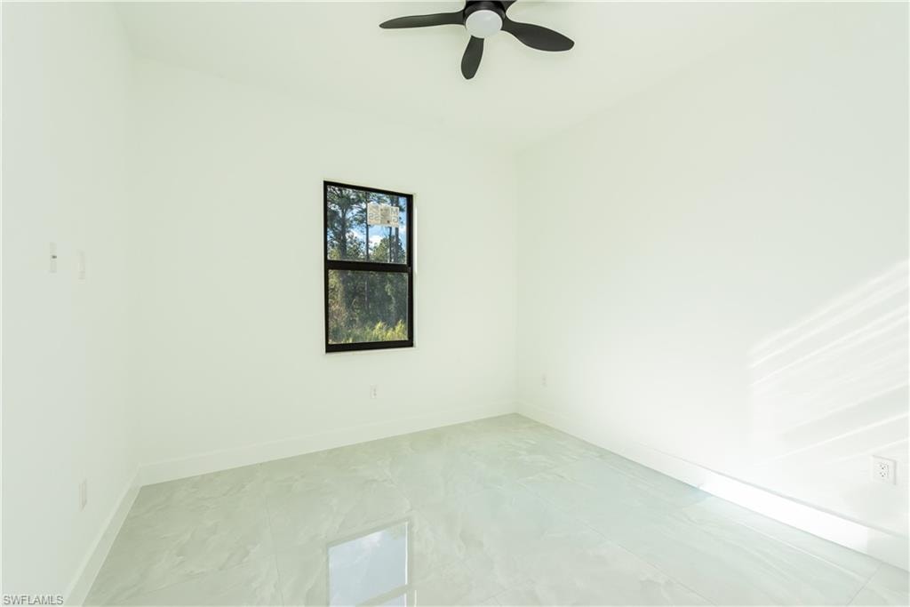 Unfurnished room with baseboards and ceiling fan