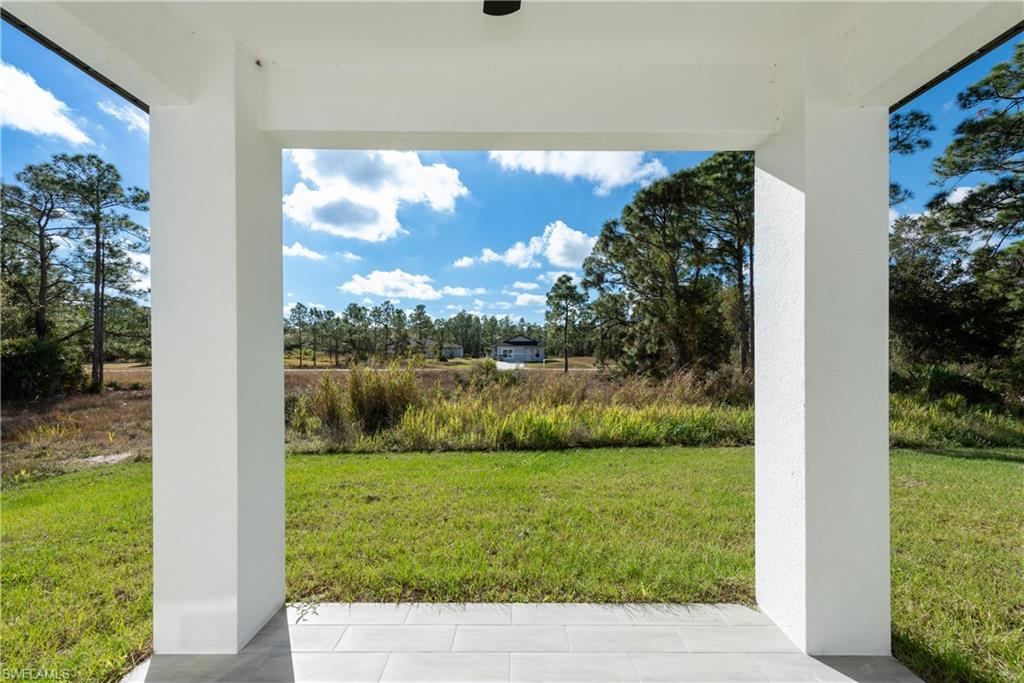 View of green lawn with a patio area