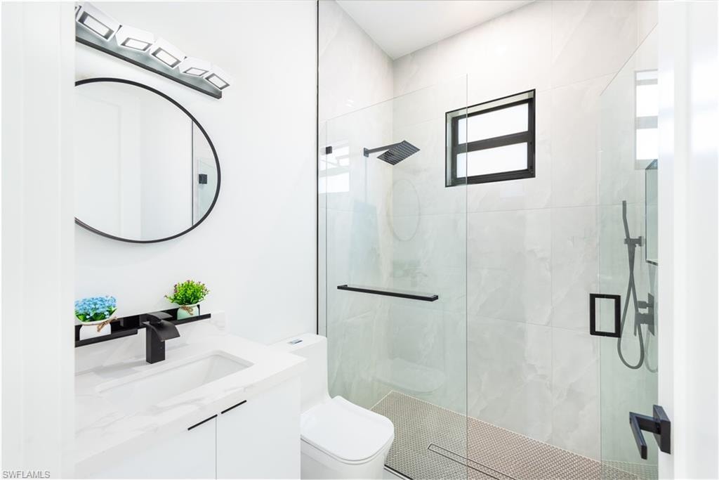 Full bath featuring a shower stall and vanity