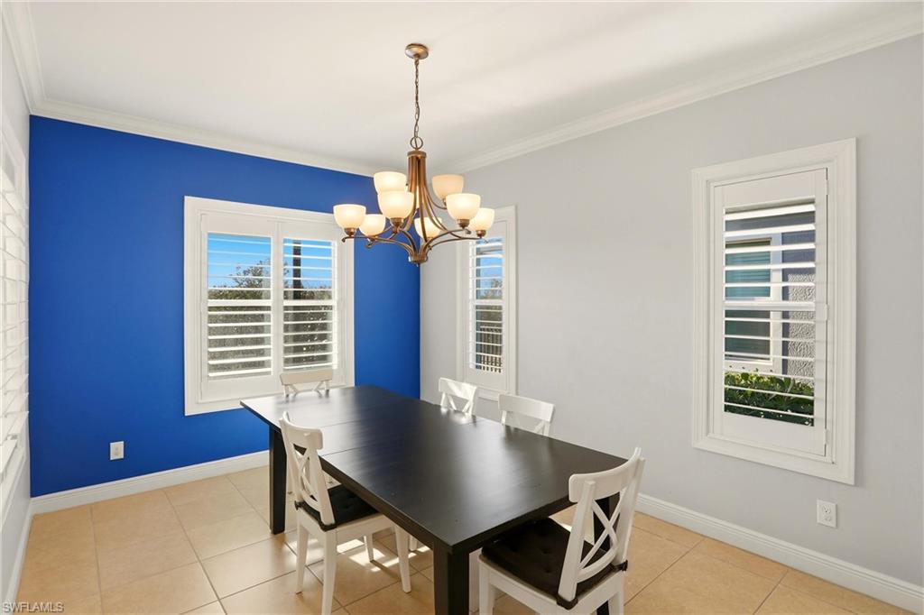 Dining room featuring crown molding, a chandelier, and light tile patterned floors