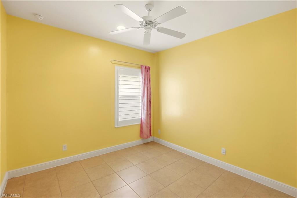 Unfurnished room with light tile patterned floors and ceiling fan