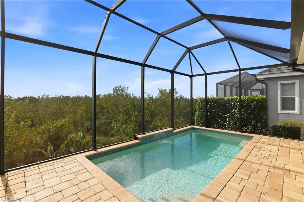 Swimming pool with a sunroom, a lanai, and a patio