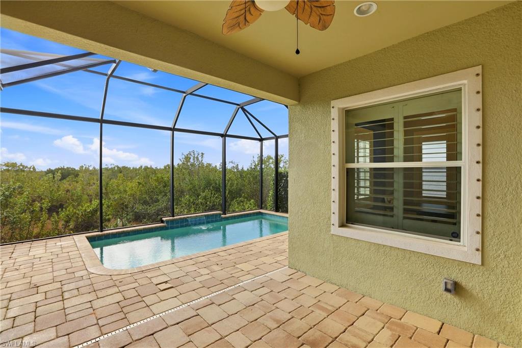 Outdoor pool with a patio area, a sunroom, and glass enclosure