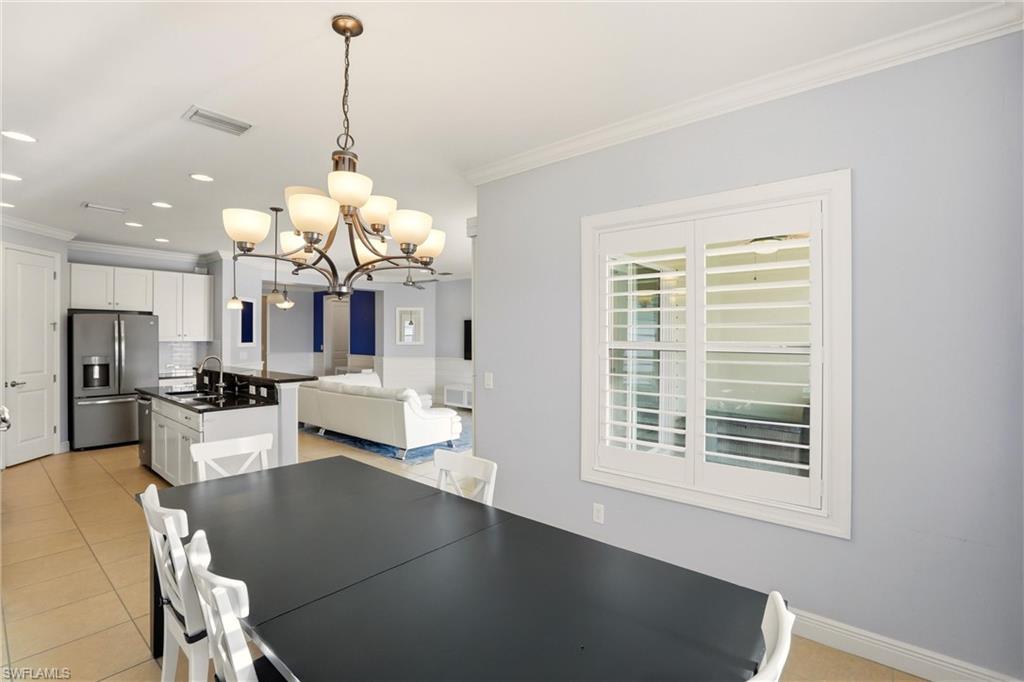 Dining space featuring crown molding, a chandelier, light tile patterned floors, and recessed lighting