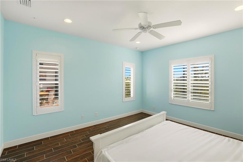 Bedroom featuring wood tiled floors, a ceiling fan, and recessed lighting