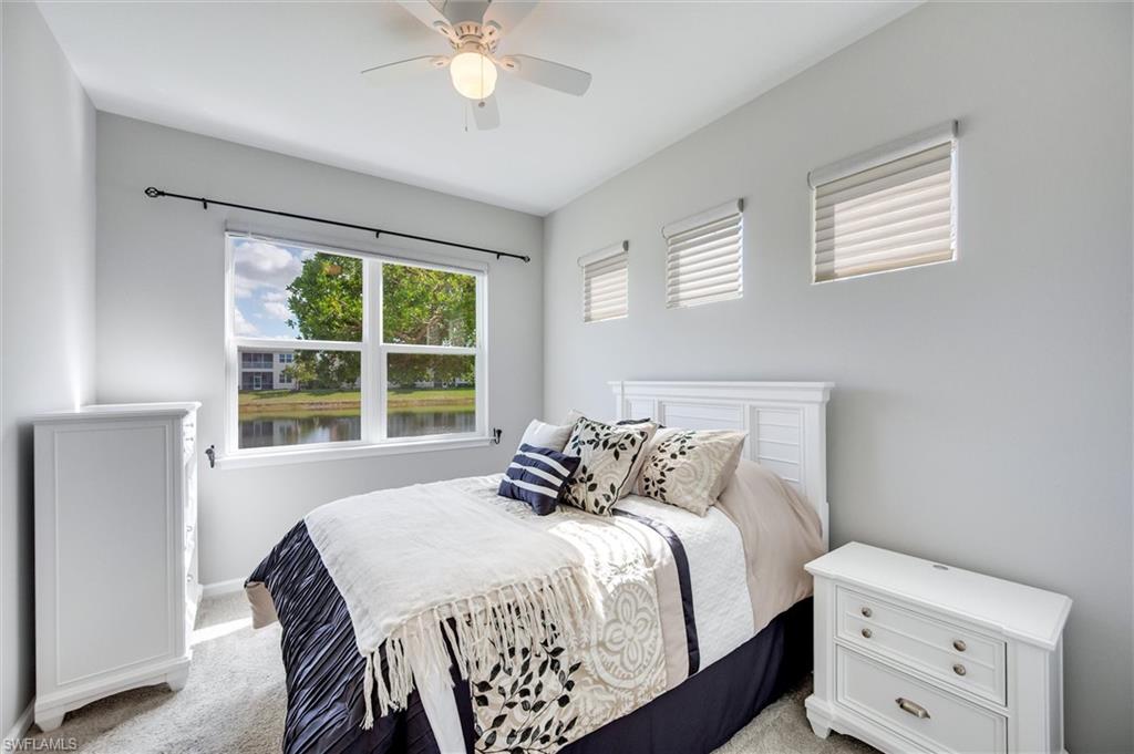 Guest Bedroom with carpet and ceiling fan and a lake view