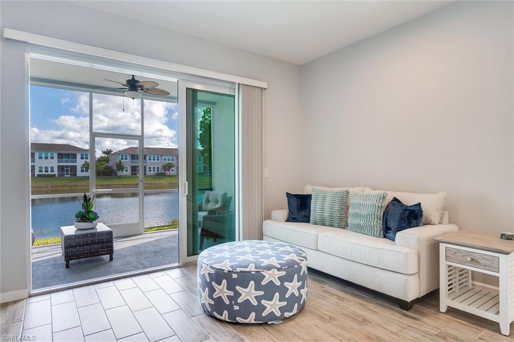 Living area with tile floors, a ceiling fan, and a water view